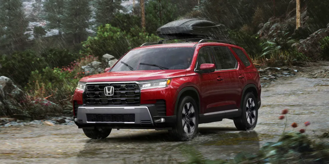 Official Picture of Radiant Red Metallic II Honda Pilot with a Roof Box on top of it